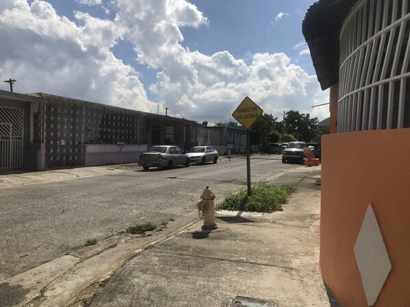 A street scene with a yellow speed reduction sign, a fire hydrant, and parked cars.