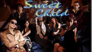 Un grupo de personas sentadas en un sofá en una habitación con poca luz, con un letrero que dice "Sweet Child".