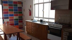 Una cocina con armarios de madera, una estufa y un ventanal.