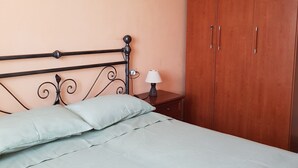 A bedroom with a bed, a nightstand, a lamp, a ceiling fan, and a wardrobe. - App.in semi-detached villa private garden and parking shared pool (Imperia)