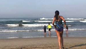 Una playa con gente caminando por la orilla.