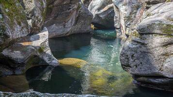 A natural rock formation with a clear water pool.
