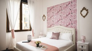 A neatly arranged bedroom with a bed, bedside tables, and a window with curtains. - St. Peter's Heart -honeymoon luxury apartment Rome (roma)
