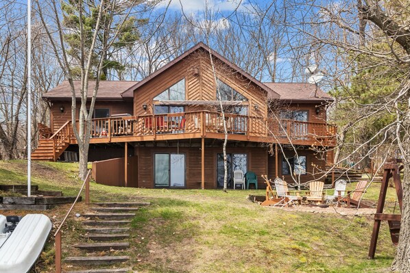 A cabin with a balcony, outdoor seating, and a slide. - Full Rec Lake w/pontoon to rent! 🏖 Beach. 🐶 friendly. (Wautoma)