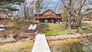 A wooden house with a deck and a dock extending into a river. - Full Rec Lake w/pontoon to rent! 🏖 Beach. 🐶 friendly. (Wautoma)