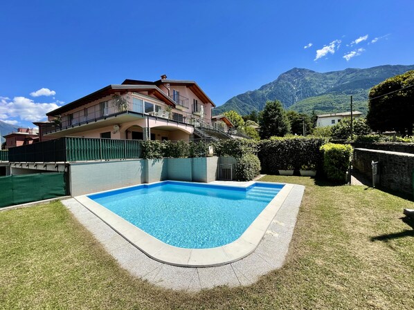 A two-story house with a swimming pool in the backyard.