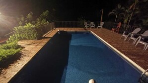 A swimming pool with a lifebuoy, surrounded by chairs and palm trees. - Villas El Ron Ron (Cartagena)