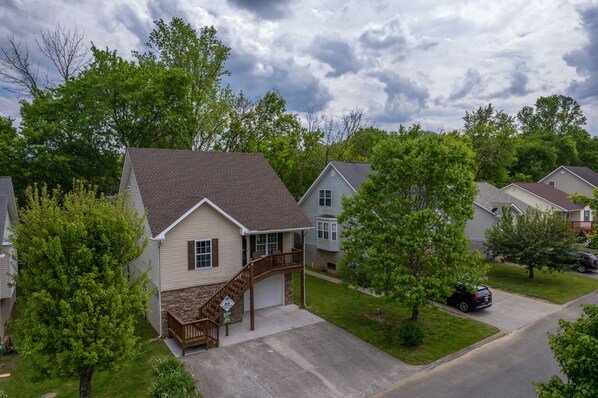 A residential neighborhood with houses featuring front porches, a central staircase, and a driveway. - Close to PF Parkway, spacious & clean 3 bedroom! Hot tub and outdoor TV on deck! (PIGEON FORGE)