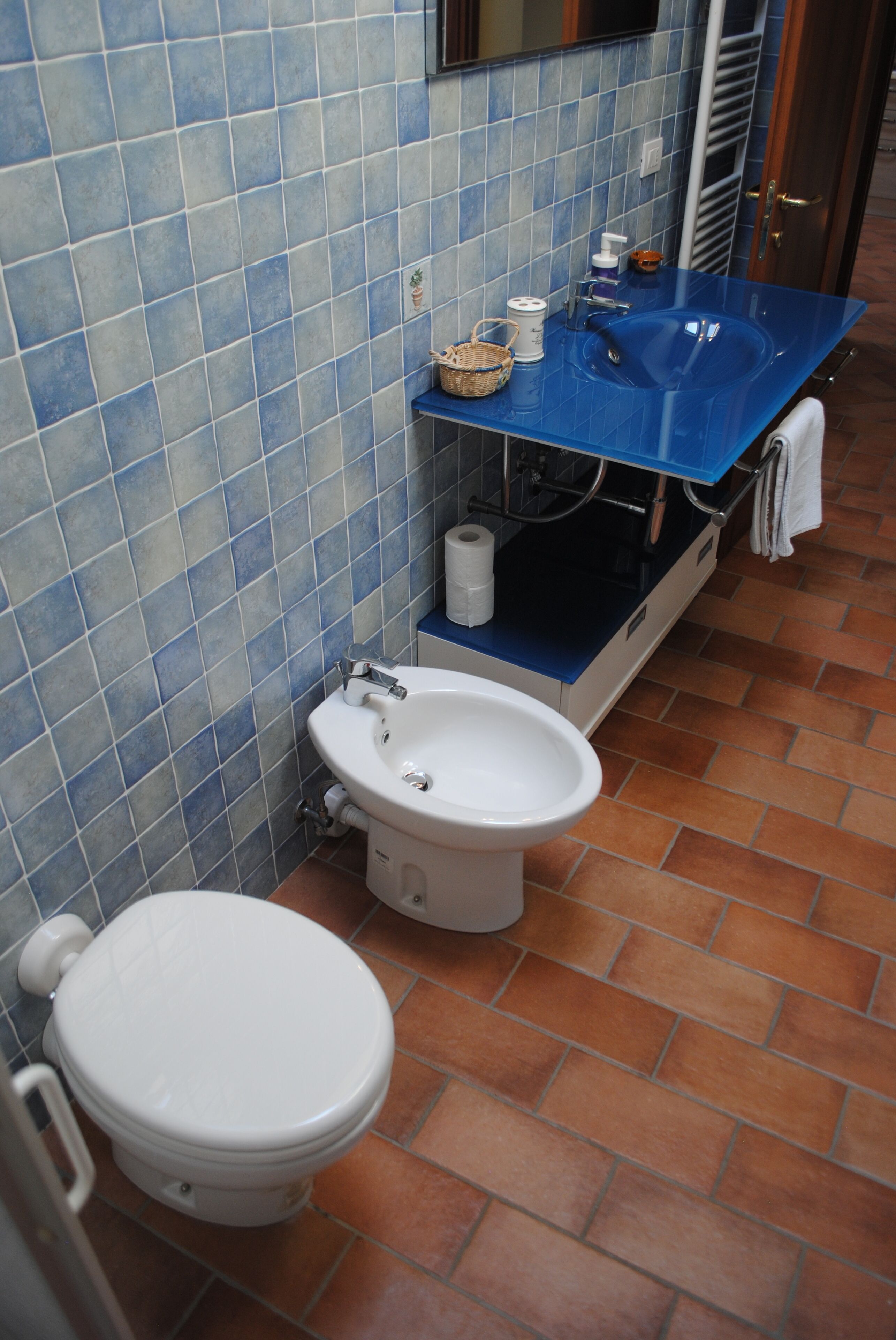 A bathroom with a toilet, bidet, and sink.