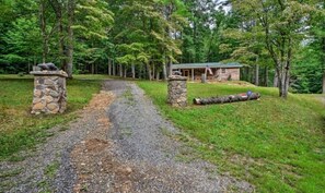 A gravel path leading to a cabin surrounded by trees.