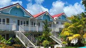 A hotel with a symmetrical facade, multiple balconies, and a central staircase leading to the upper floors. - Apartment 30 metres from the beach (Sainte-Luce)