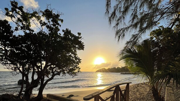 A wooden staircase leading to a beach with a sunset in the background. - Apartment 30 metres from the beach (Sainte-Luce)
