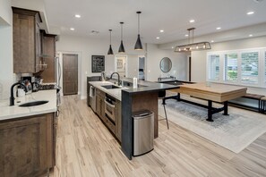 Enjoy cooking in this well-equipped kitchen with a central island, sink, and ample counter space.