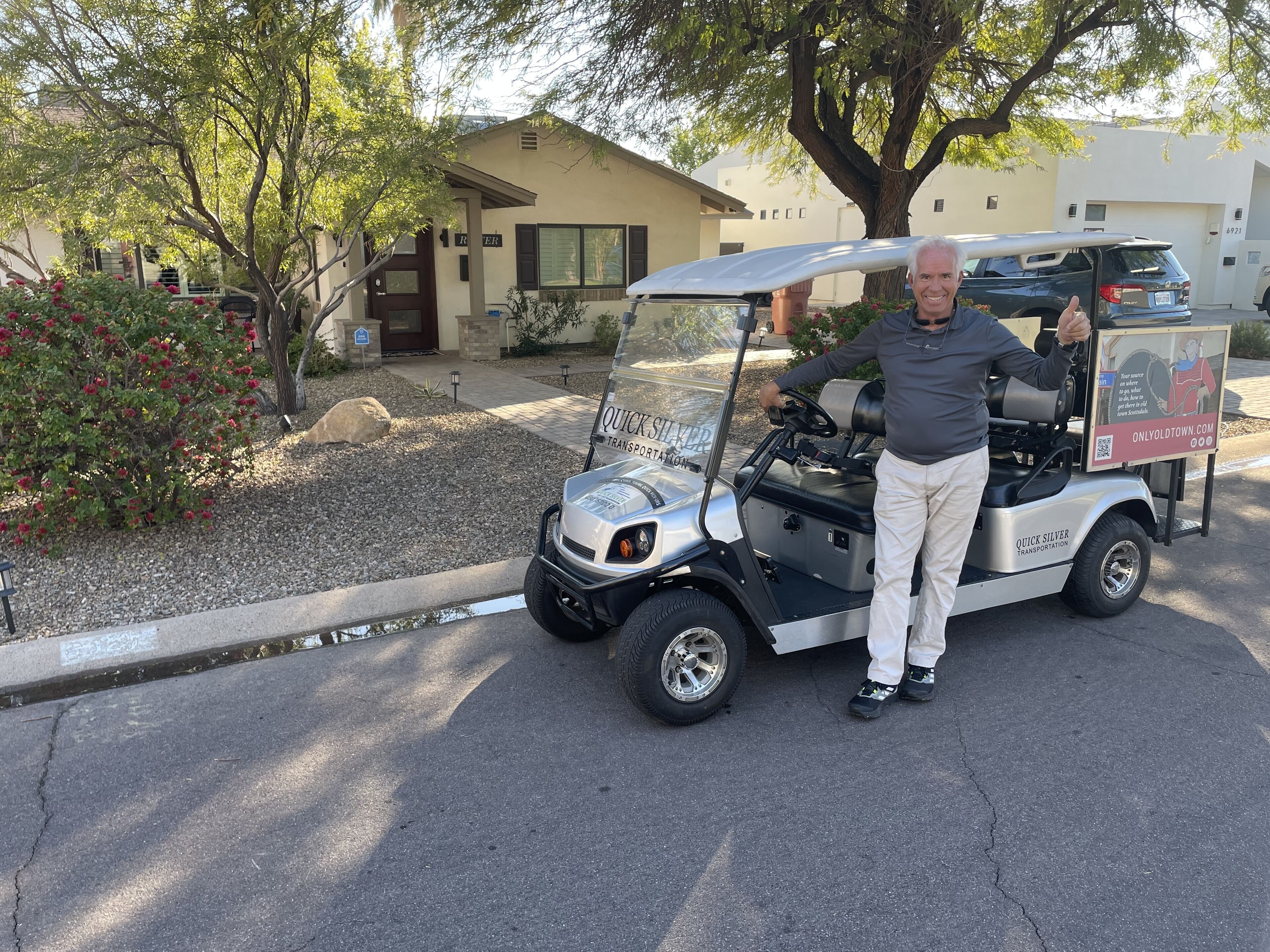 A golf cart parked in a driveway with a house in the background.