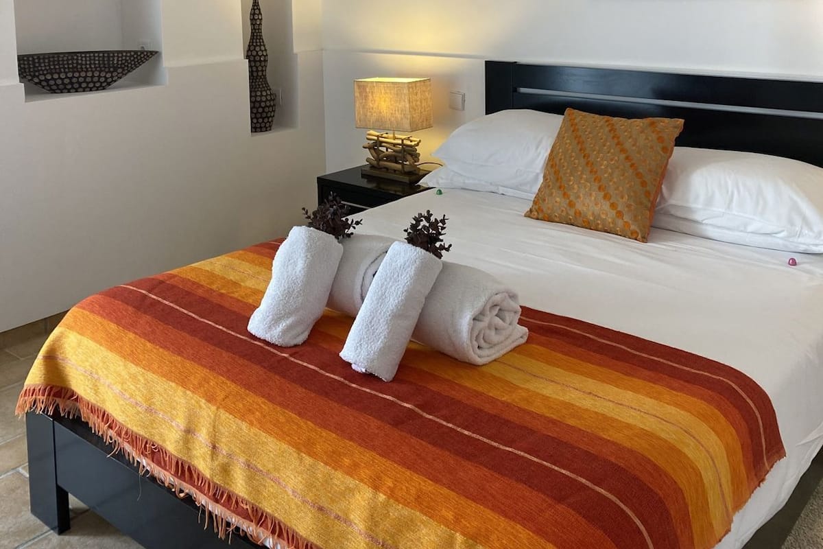 Een hotelkamer met een bed, een schilderij, een nachtkastje, een lamp en een decoratief muurdecoratie.