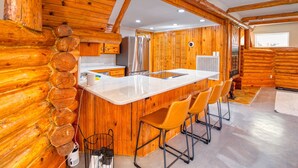 A log cabin interior with a kitchen, bar area, and seating. - 6Bdrm Cabin Walk to Beach Pool-Table Firepit! (Kingston)