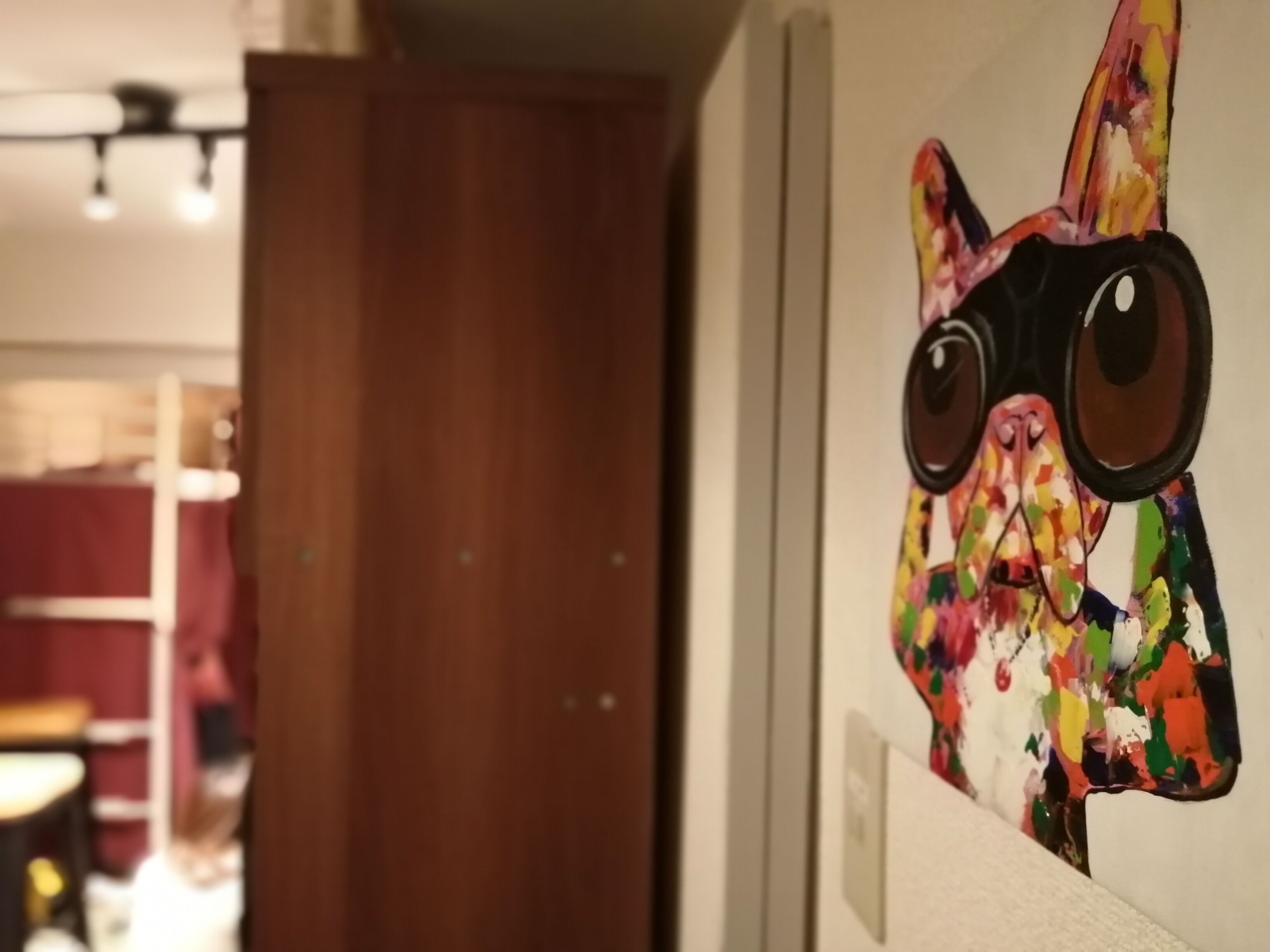 A colorful wall art of a cat with glasses.
