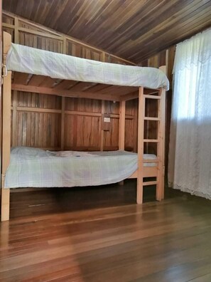 Ein Stockbett mit Holzrahmen und einer Matratze.