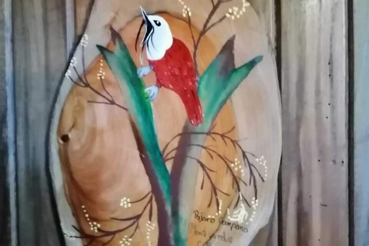 A wooden artwork featuring a bird on a branch.