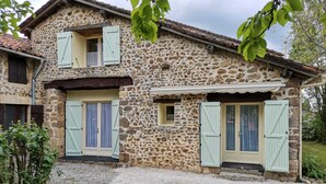 A stone house with two doors and windows, a gravel driveway, and a small garden area. - 3 Bedroom  character property (L'Âge)
