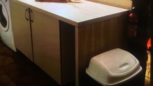 A kitchen with a microwave, a bread basket, and a bottle of sauce on the counter. - 3 Bedroom  character property (L'Âge)