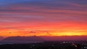 A sunset over a mountainous landscape with a view of a city below.