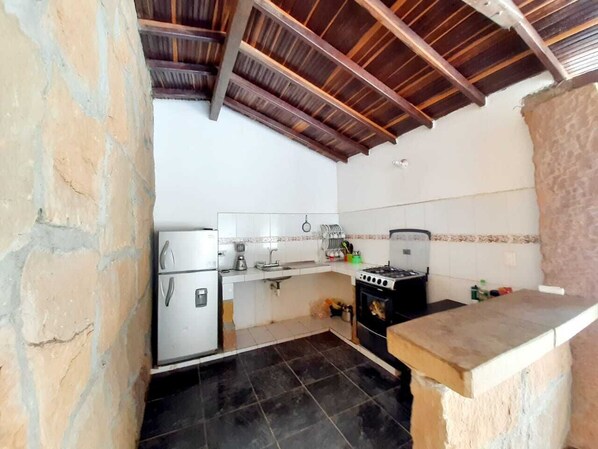 Compact kitchen with a modern design, featuring a refrigerator, stove, and sink.