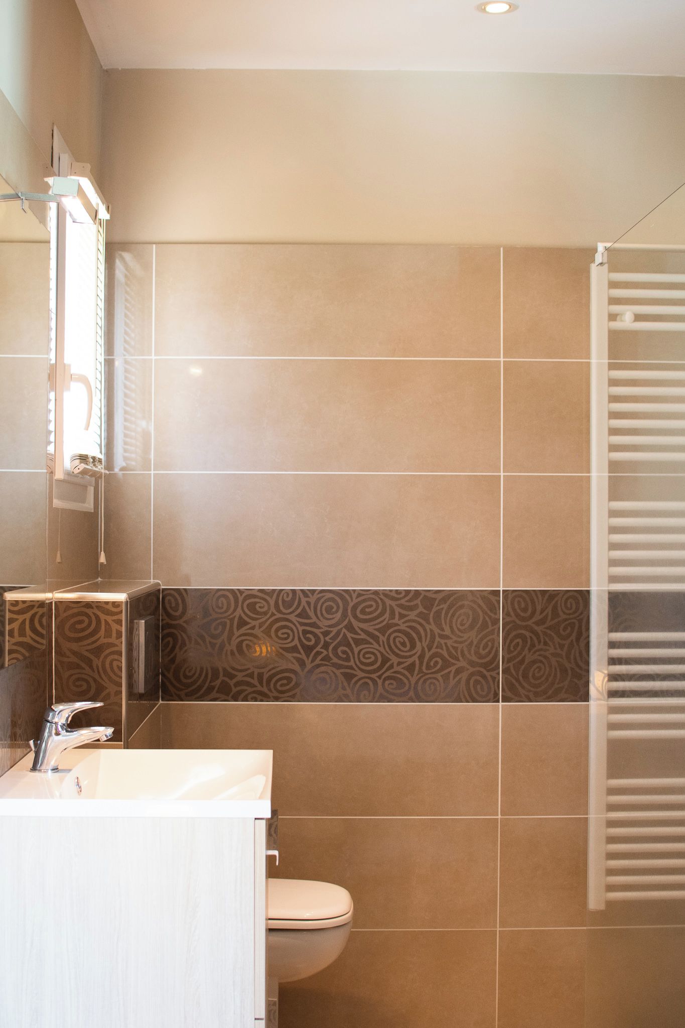 Un baño con ducha, inodoro y lavamanos con espejo.