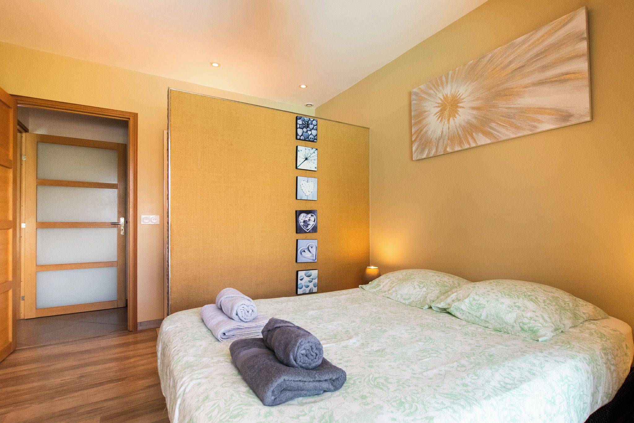 Una habitación de hotel con una cama, un reloj en la pared y una puerta.