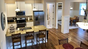 A modern kitchen with a central island, stainless steel appliances, and pendant lighting.
