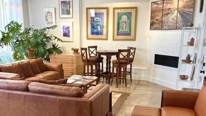 A modern living room with a brown leather sofa, a dining table with chairs, a ceiling fan, and artwork on the walls. - Marfa House El Balcon, in the heart of Marfa with direct balcony access (Marfa)