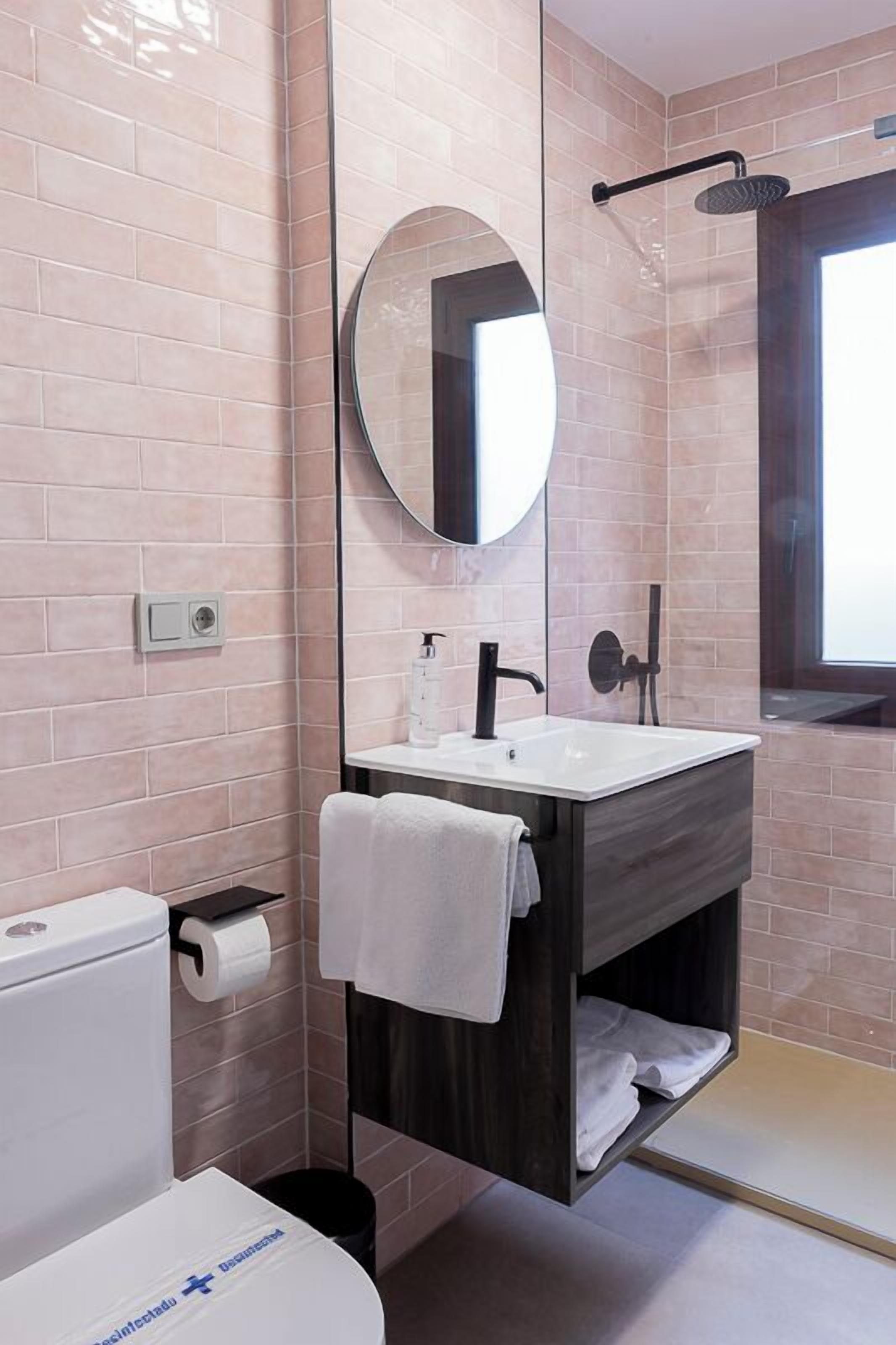 Un baño moderno con inodoro, lavamanos, espejo e hidromasaje.