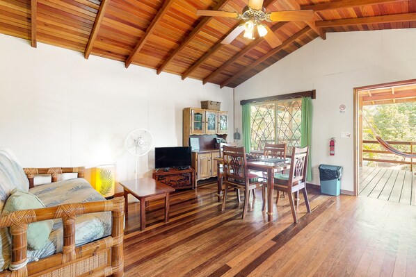 Relax in this spacious living area with a comfortable sofa, dining table, and TV.