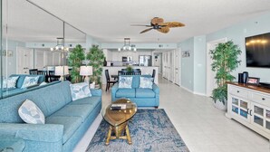 A spacious living area with a sofa, coffee table, and a ceiling fan.