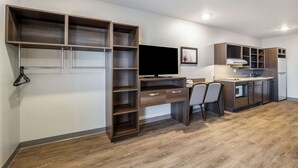 Una cocina compacta con estanterías integradas, comedor y televisor.