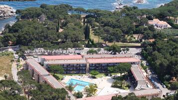 Vista aérea de un hotel con un patio central, varias construcciones y una piscina.