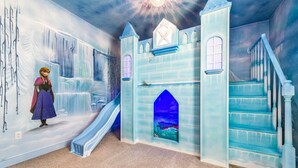 A room with a castle-themed play area, including a slide and a staircase.