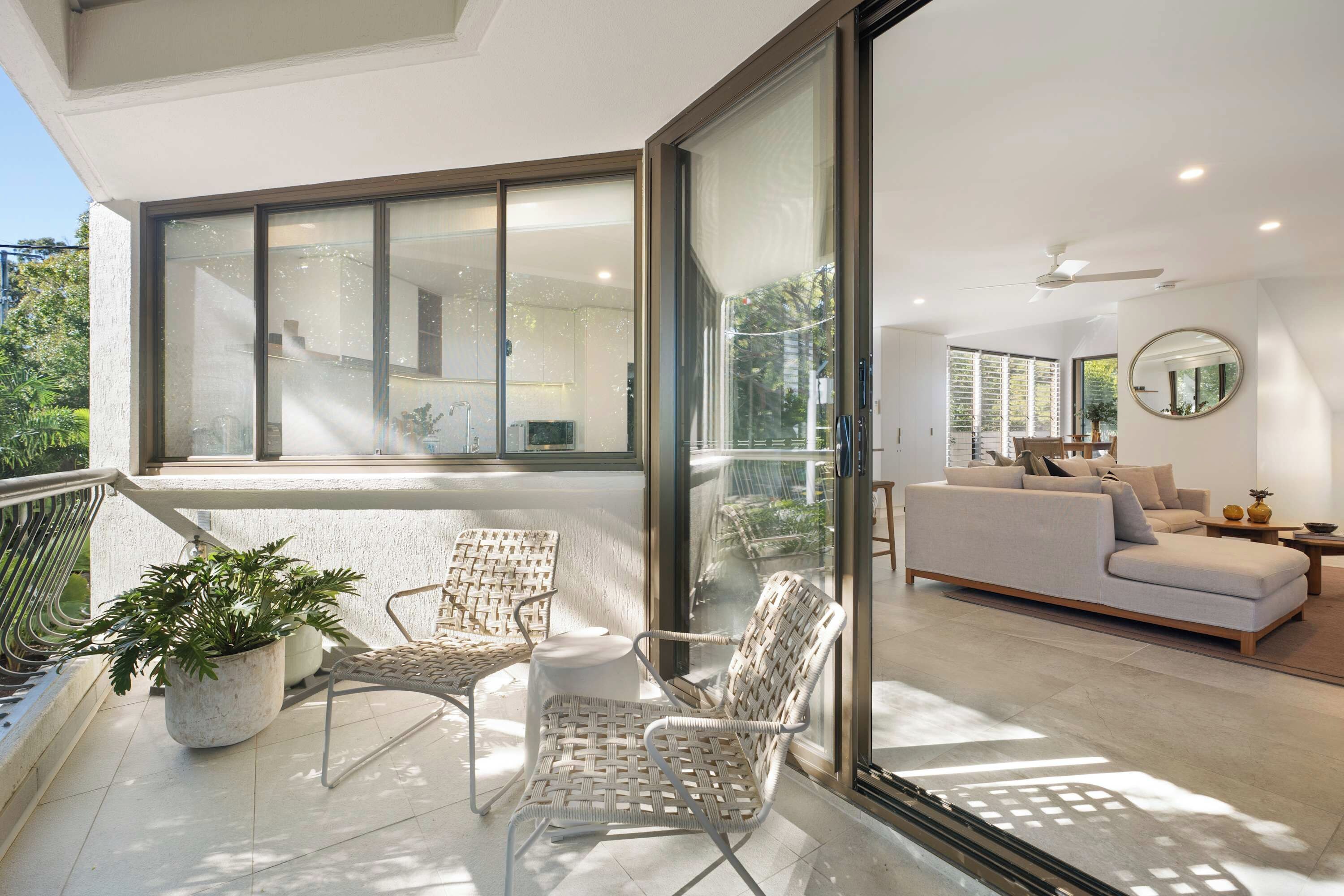A modern living room with a sofa, a dining table, and a large window.
