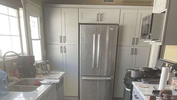 A modern kitchen with stainless steel appliances, dark tiled flooring, and white cabinetry. - Minutes to Disneyland, Knotts, Wild Rivers, Anaheim Conv Ctr, Angels, Ducks, HOB (Orange)
