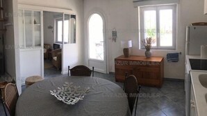 Un'ampia stanza con angolo ristoro, un armadio in legno e una finestra che lascia entrare luce naturale.