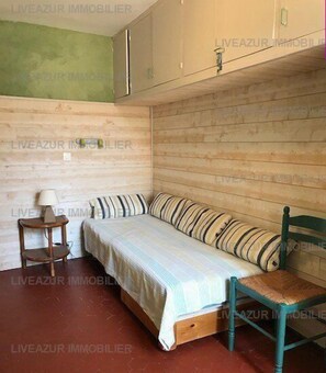 Una habitación pequeña y acogedora con una cama individual, una silla y una mesita.