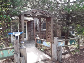 A wooden gate with a decorative arch leading to a building entrance.