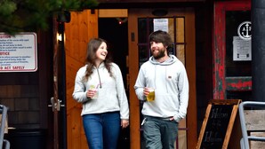 Two people walking up wooden steps outside a building with a sign that reads "Welcome to the Hotel." - Anchor Inn Resort (Lincoln City)