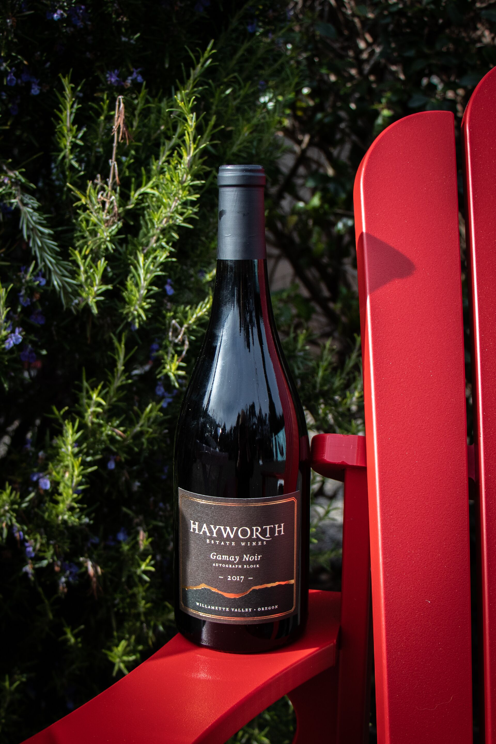 Uma garrafa de vinho Hayworth Gamay Noir sobre uma cadeira vermelha.