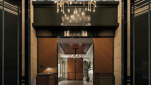 A modern lobby with a central chandelier, wooden paneling, and a reception desk. - The Aoyama Grand Hotel (Tokyo)