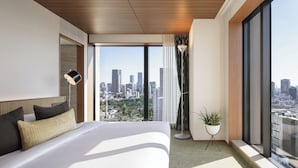 A modern hotel room with a large bed, city view, and a potted plant. - The Aoyama Grand Hotel (Tokyo)
