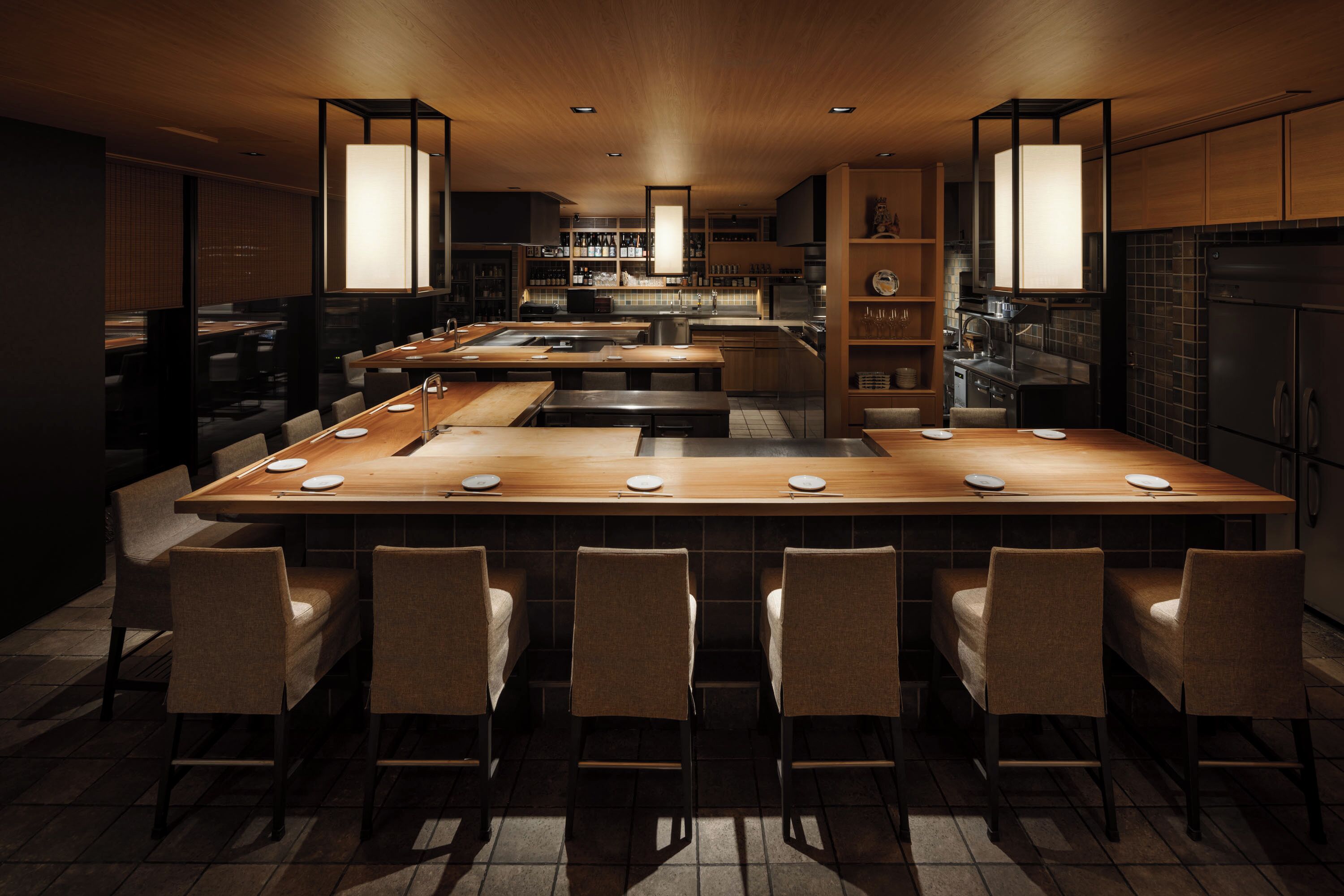 Een moderne keuken met een centraal eiland, een bar en hanglampen.