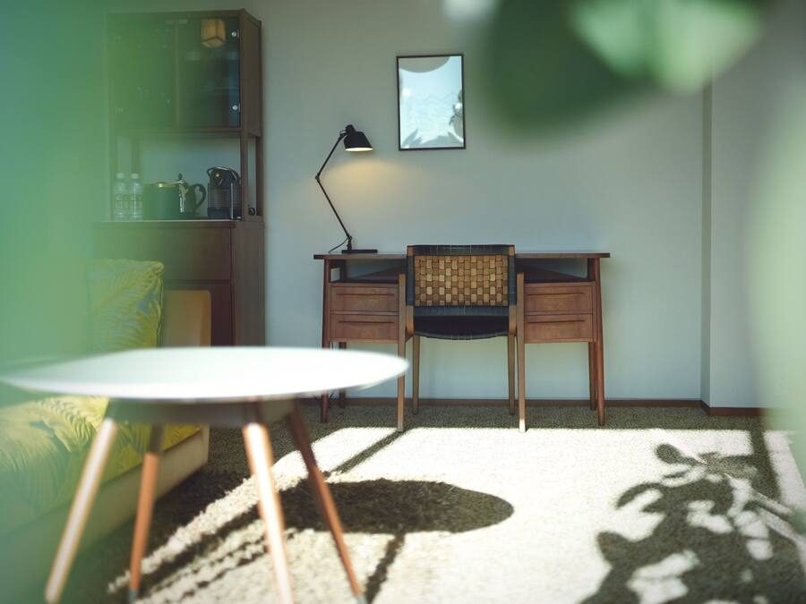 Une pièce comprenant un bureau, une chaise, une petite table et une bibliothèque.