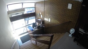 Una escalera con barandilla de madera que baja a un nivel inferior.