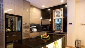 Una cocina moderna con una isla central, electrodomésticos integrados y vistas a la ciudad.
